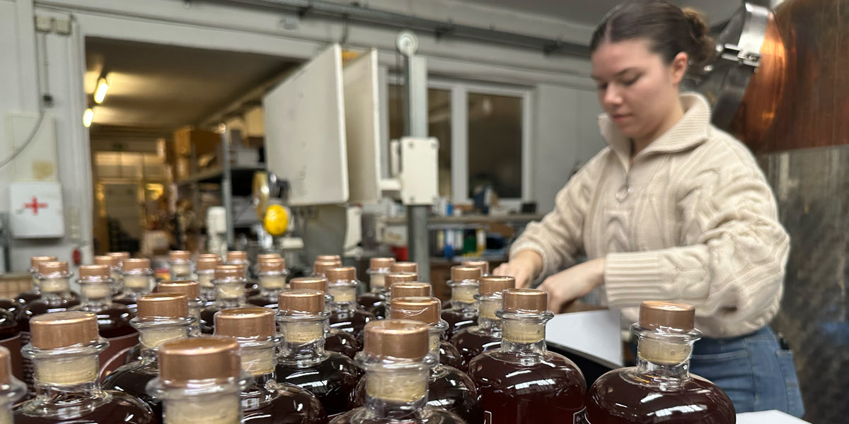 Gründerin beim verpacken des Mannemer Dreck Likörs, im Vordergrund viele Flaschen MANNI